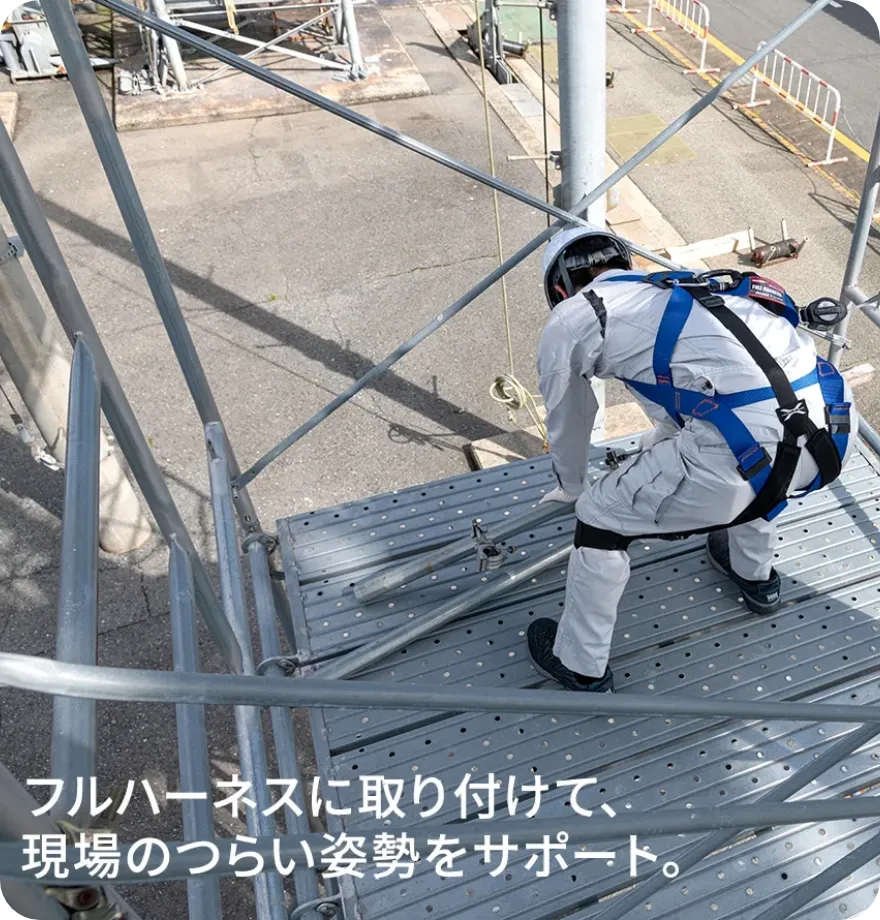 フルハーネスにマッスルスーツを取り付けて、作業をしている作業員